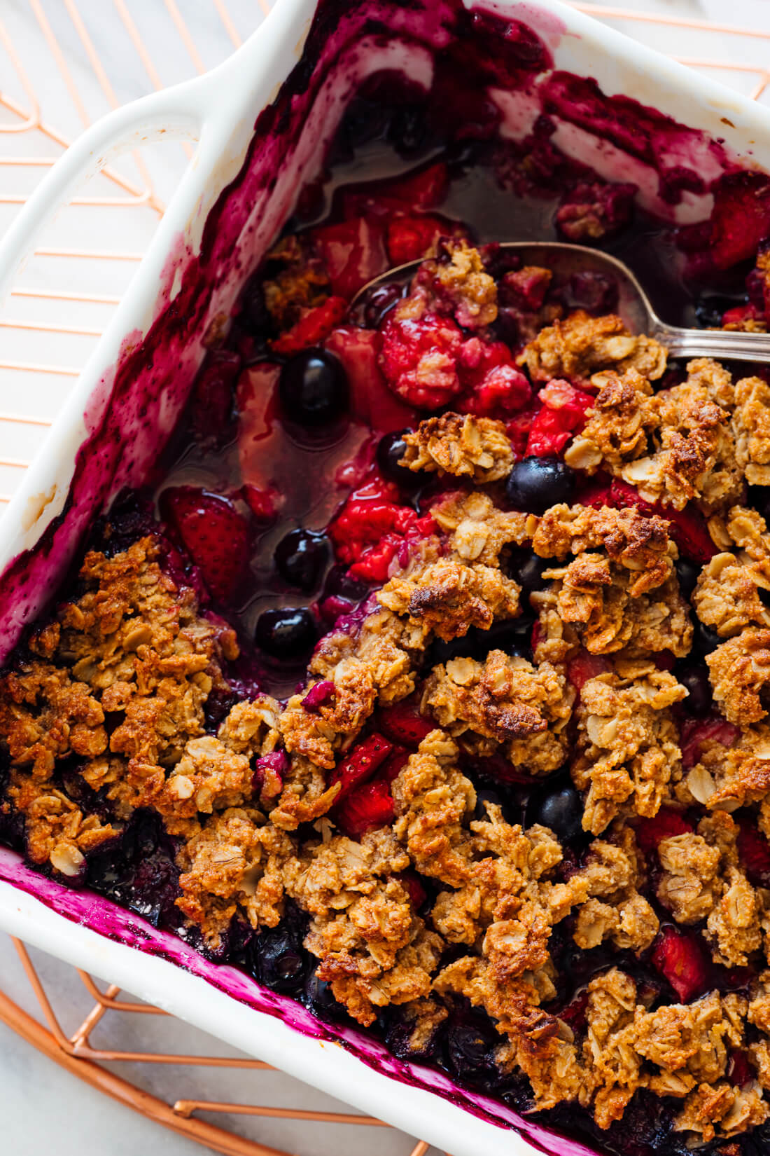 mixed berry crisp with serving spoon